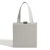 Minimalist grey textured jewelry gift box with ribbon handles for Crystia cross necklaces.