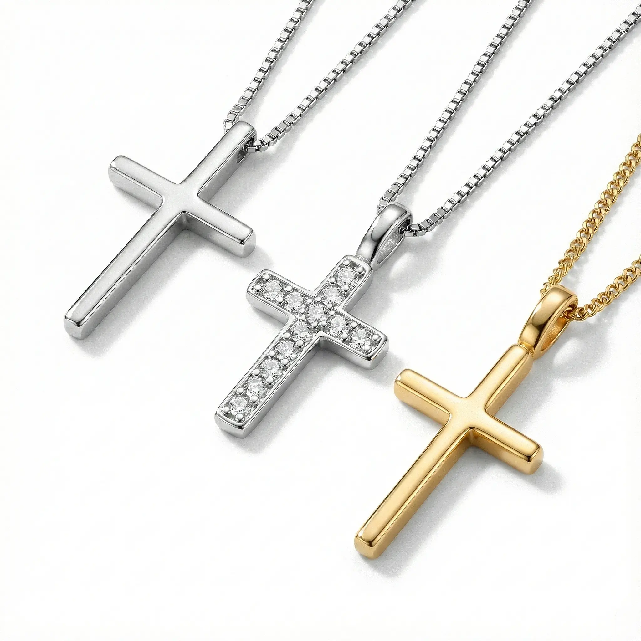 Trio of dainty cross necklaces: A minimalist polished silver cross, a silver cross pendant with pave-set crystals, and a simple polished gold cross on fine box chains.
