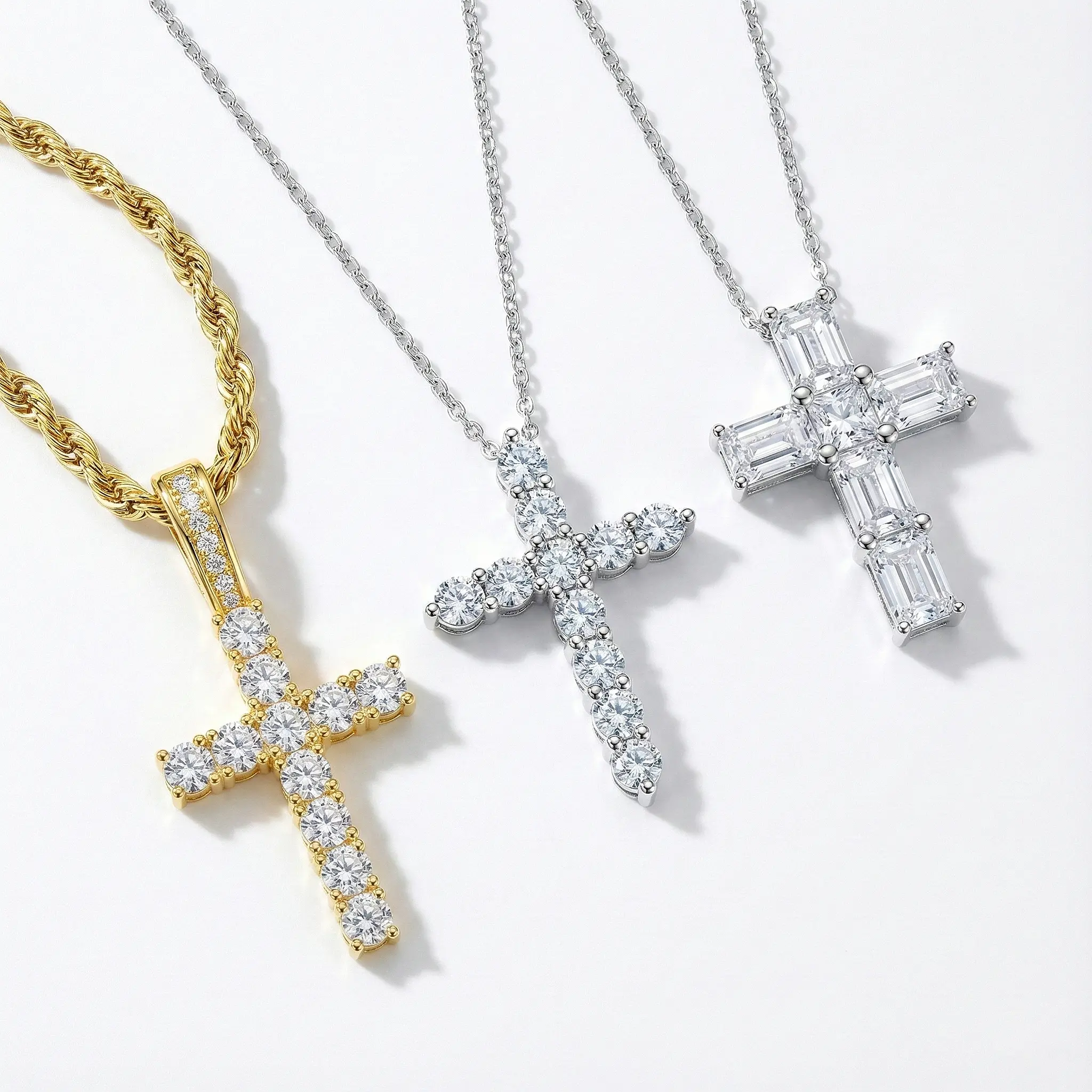 Trio of simulated diamond cross necklaces: Gold pave cross on rope chain, classic silver round-cut pendant, and luxury baguette-cut silver cross.