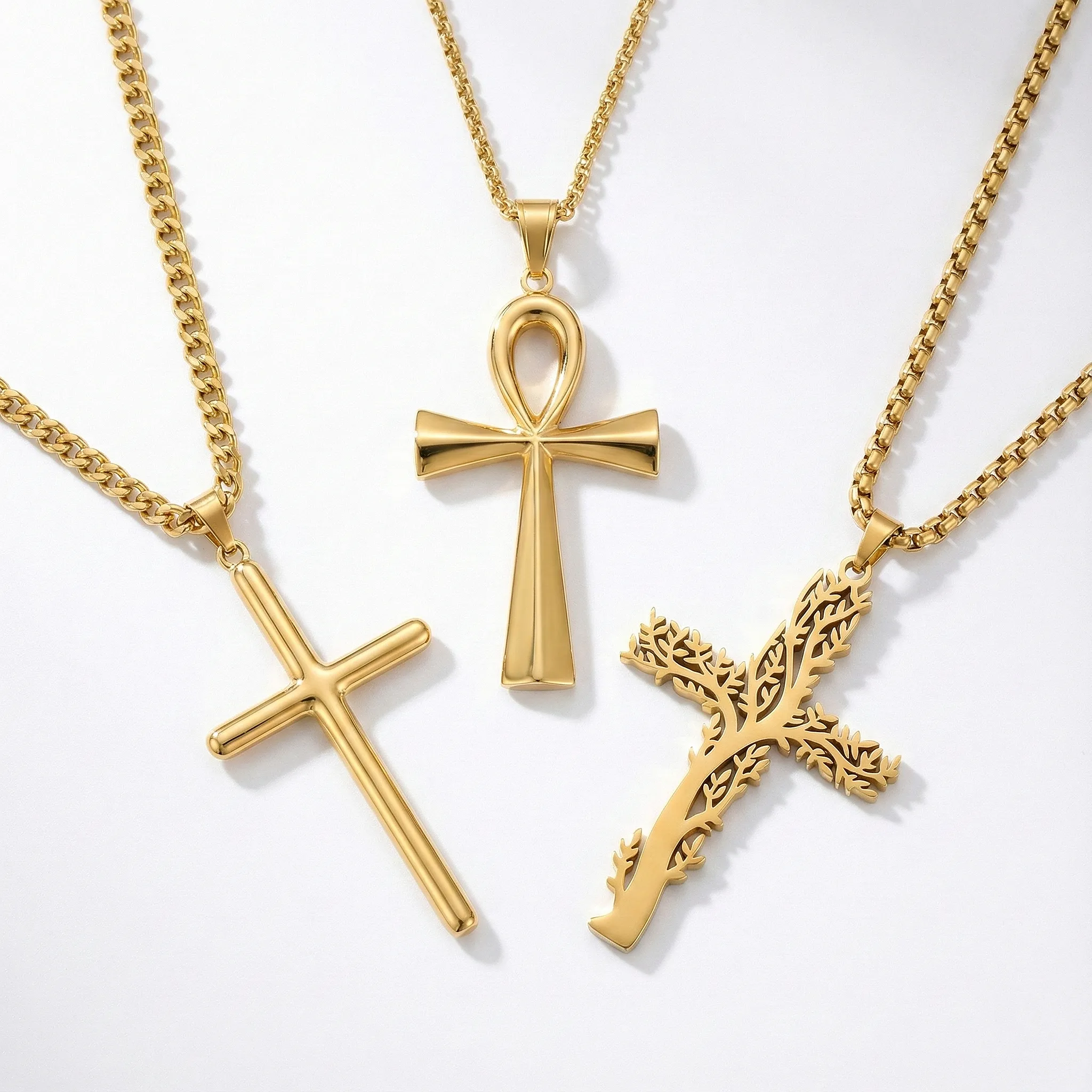 Gold women's cross necklaces: simple polished cross, Egyptian Ankh pendant, and detailed vine-patterned tree of life cross.