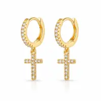 Pair of gold huggie hoops with clear stone front and pavé cross drops, white background
