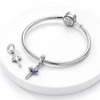 Blue butterfly cross dangle on a snake chain bracelet, second charm showing its open reverse