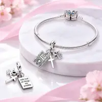 Catholic dangle charm threaded on a silver snake bracelet, verse side shown on marble
