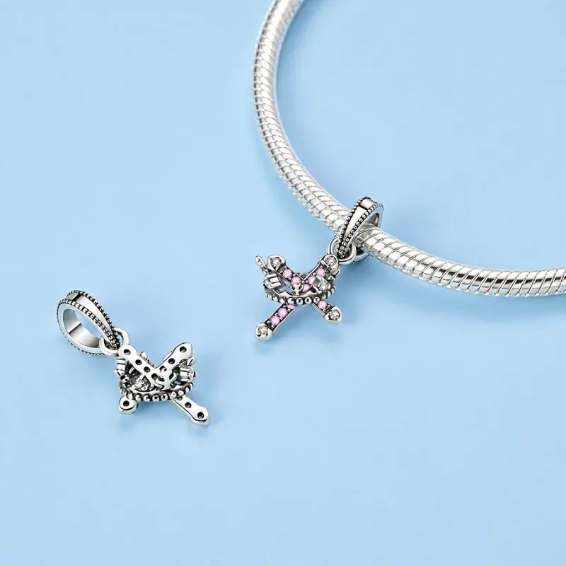 cross and crown charm stefan Crown and cross charm shown front and reverse beside a silver snake chain bracelet