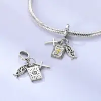 Jesus fish charm shown front and reverse beside a silver snake chain bracelet