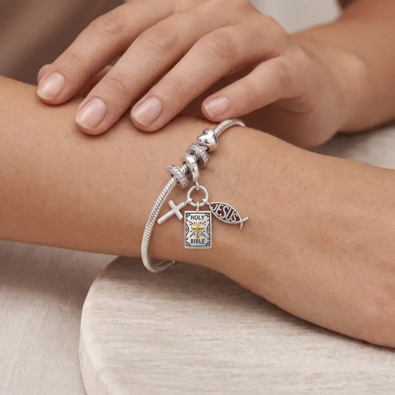 cross fish charm Woman's wrist wearing the fish and Bible charm on a snake chain with pavé spacers