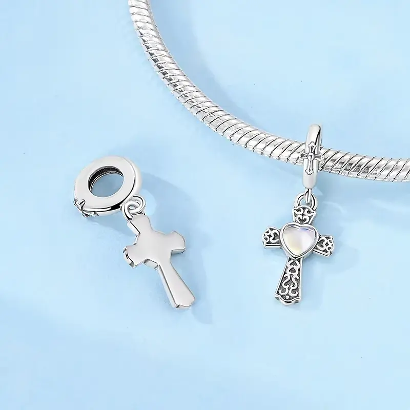 gothic cross charms lierne Gothic silver cross charm front and plain reverse beside a snake chain bracelet