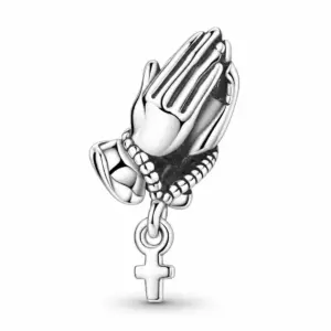 Sterling silver praying hands charm with small hanging cross, side angle on white background
