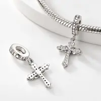 Front and pierced back of an infinity cross charm, one threaded on a snake bracelet