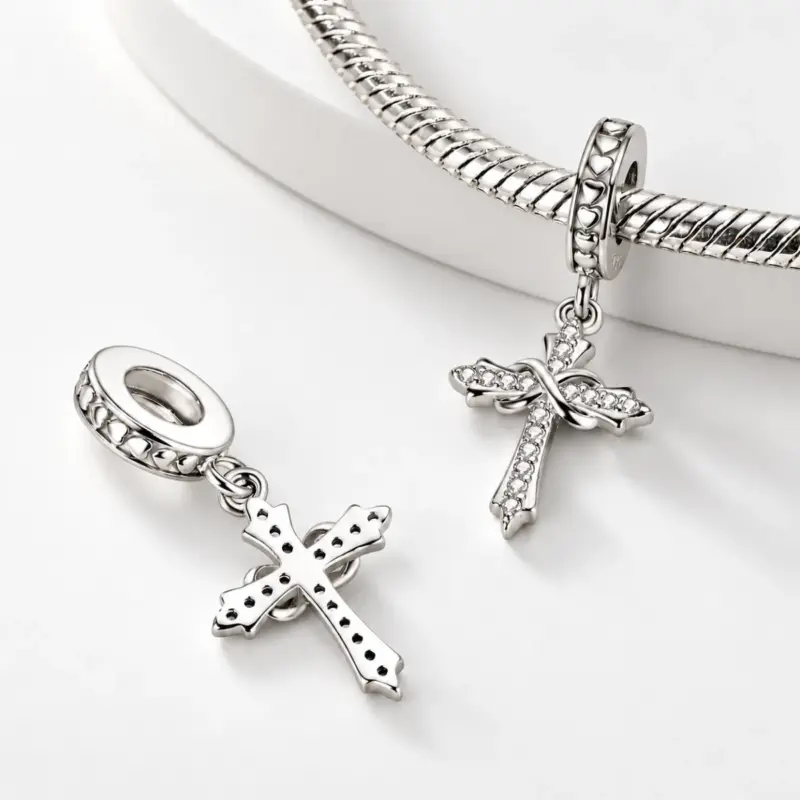 silver cross dangle charm perpetua Front and pierced back of an infinity cross charm, one threaded on a snake bracelet