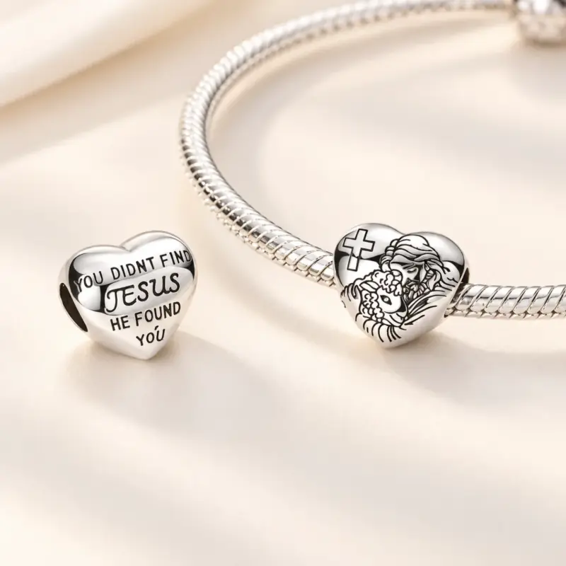 jesus cross charmâ Silver Jesus heart charm on a snake chain bracelet beside its verse side, cream satin