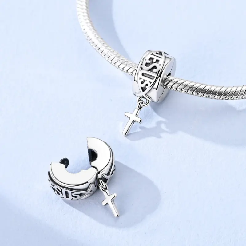 mens-cross-charm-snake-chain Men's silver cross charm clipped onto a snake chain bracelet, front view