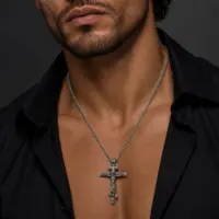Man wearing an oxidized Orthodox cross pendant over an open black shirt