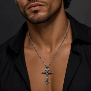 Man wearing an oxidized Orthodox cross pendant over an open black shirt