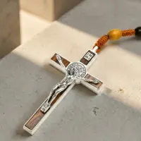 Close-up of silver cross pendant on tiger eye beaded necklace