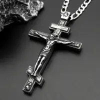 Three-bar Orthodox cross pendant angled on dark stone, corpus and skull in relief