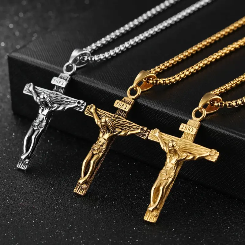crucifix-pendant-three-finishes Three crucifix pendant necklaces in gold, retro gold and silver on a dark surface