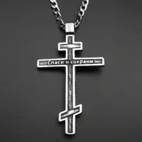 Engraved Cyrillic reverse of the steel Orthodox cross pendant on a dark surface