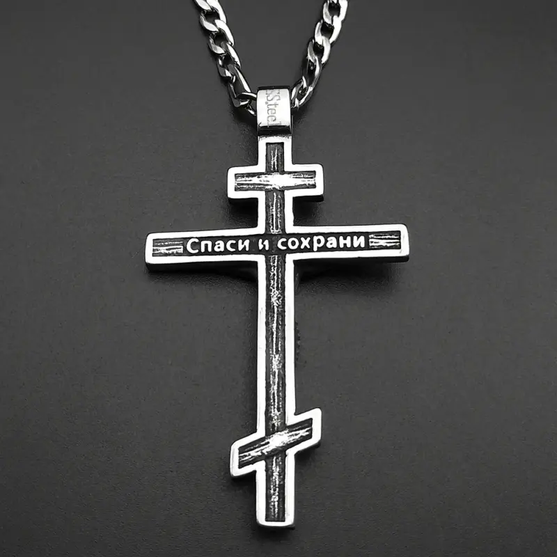 engraved-reverse-orthodox-cross Engraved Cyrillic reverse of the steel Orthodox cross pendant on a dark surface