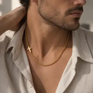 Man wearing the sideways gold cross chain with an open linen shirt in daylight