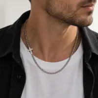 Man wearing the steel offset cross chain over a white tee and black shirt