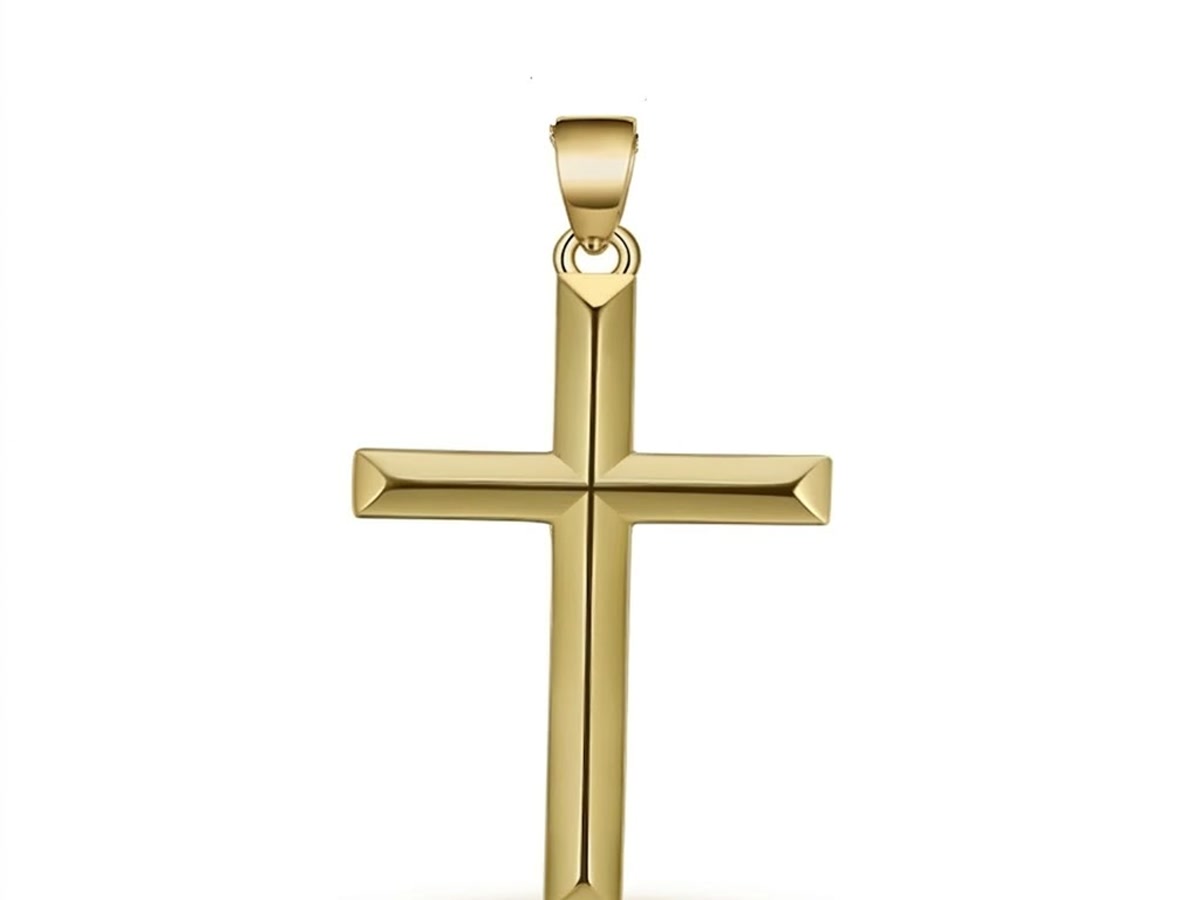 Gold plated cross pendant whose plating wears thin at the edges, revealing the copper rich base metal underneath.